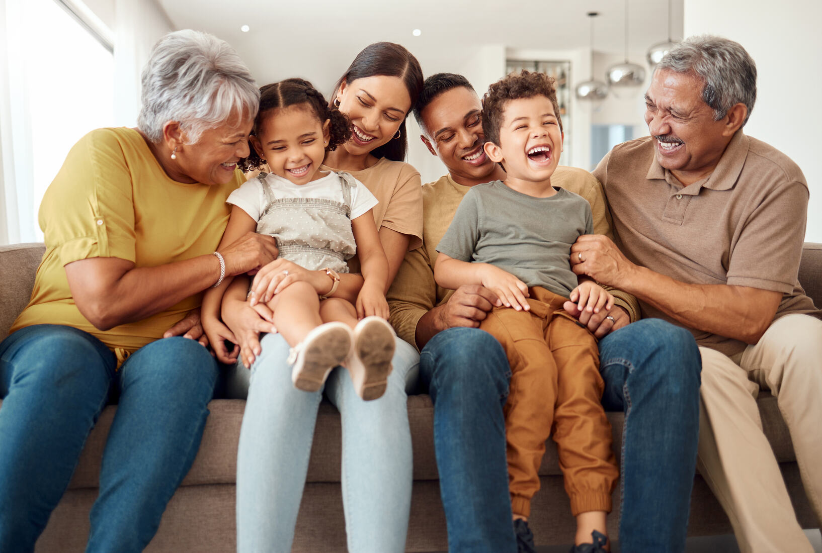 Família reunida rindo no sofá